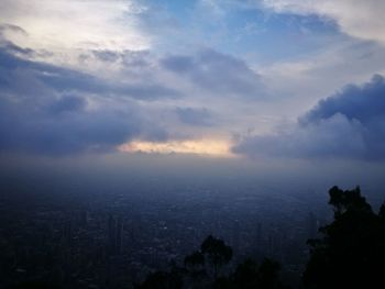 High angle view of silhouette trees and buildings against sky