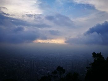 High angle view of silhouette trees and buildings against sky