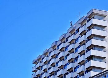 Low angle view of modern building against clear blue sky