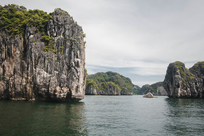 Rock formations by sea against sky