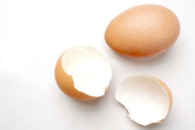 High angle view of broken egg against white background