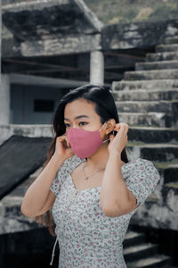 Portrait of woman standing against wall