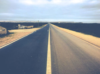 Empty road along countryside landscape