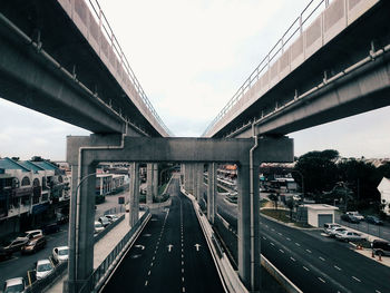 Bridge over road in city against sky