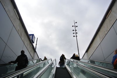 People on escalator against sky