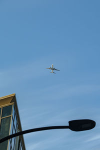 Low angle view of airplane flying against clear sky