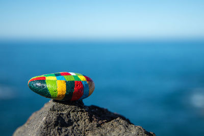 Close-up of multi colored pebble on rock against sea