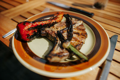 High angle view of iberico chop, green onions and sweet pepper on a plate