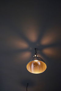 Low angle view of illuminated light bulb against sky