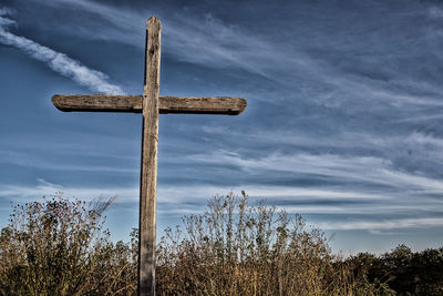 Low angle view of cross on tree against sky