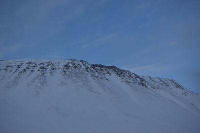 Scenic view of snowcapped mountain against blue sky