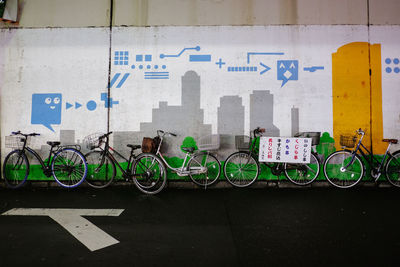 Bicycle parked against graffiti wall