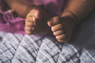 Low section of baby on bed