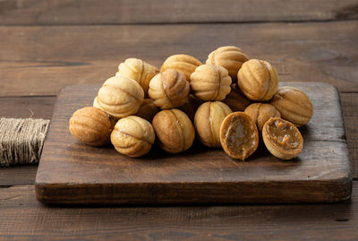 Baked dessert nuts with condensed milk on a wooden board, top view