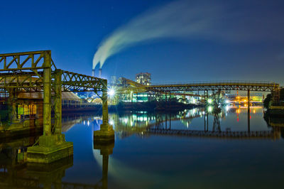 Illuminated bridge over canal against sky at night