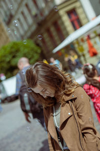 Smiling young woman standing on street in city