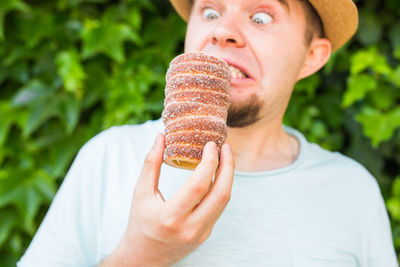 Close-up of man making friend holding sweet food outdoors