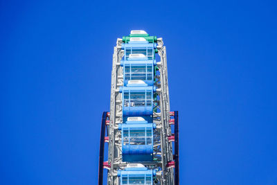 Low angle view of illuminated tower against clear blue sky