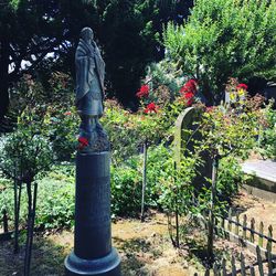 Statue against plants and trees