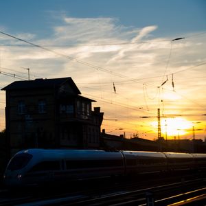 Cars on road against sky at sunset