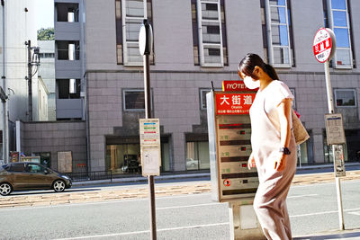 Full length of woman walking on road in city