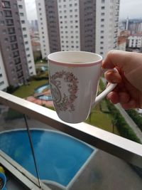 Close-up of hand holding coffee cup