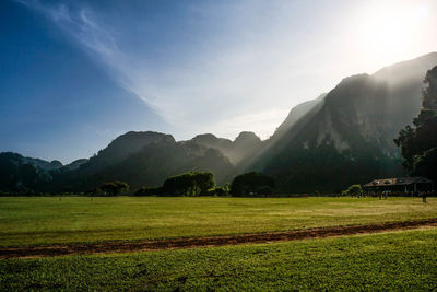 Scenic view of field and mountains against sky