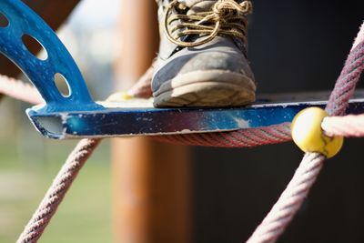 Close-up of sports shoe on outdoor play equipment