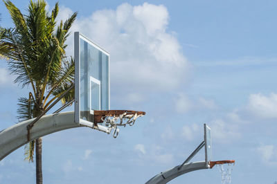 Low angle view of basketball hoop and tree against sky