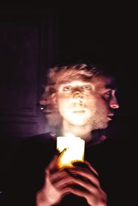 Close-up portrait of woman in dark room