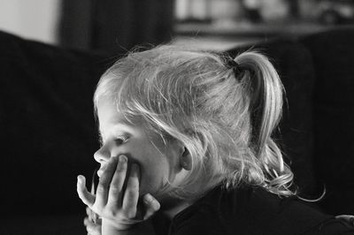 Close-up of cute girl looking away at home 