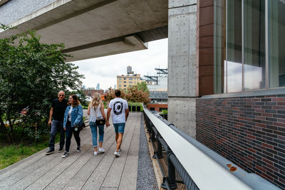 Rear view of people walking along buildings