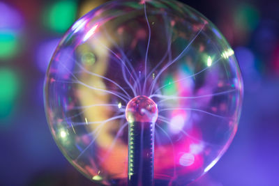 Close-up portrait of woman holding illuminated lighting equipment in room