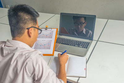 Side view of man using laptop at home