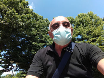 Portrait of young man against trees