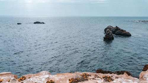Rocks on sea shore against sky