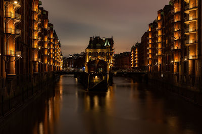 Wasserschloss in old part of speicherstadt with store houses illuminated at night