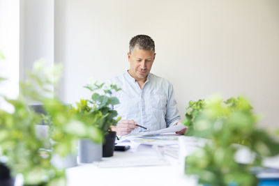 Young man using laptop while sitting on table