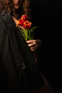 Beautiful red tulips flowers in hand on a black background. congratulations on women's