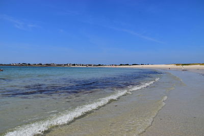 Scenic view of beach against blue sky