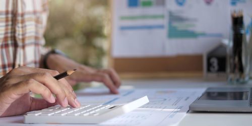 Cropped image of man using mobile phone on table