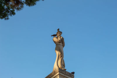 Low angle view of statue against clear blue sky