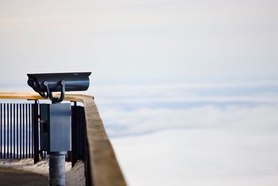 Close-up of security camera against sky