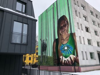 Low angle view of woman standing against building in city