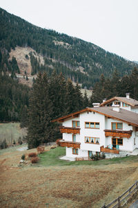 Houses by trees and buildings against sky