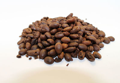 High angle view of coffee beans against white background