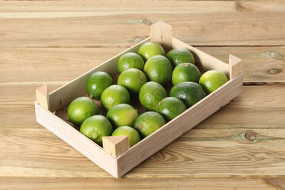 High angle view of fruits in container on wooden table