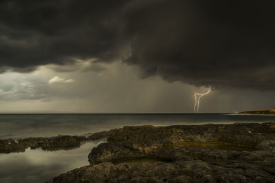 Scenic view of sea against storm clouds