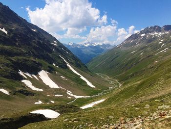 Scenic view of mountain range against cloudy sky