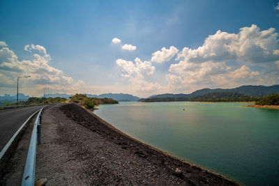 Road by lake against sky